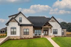 a white brick house sitting on top of a lush green field