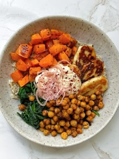 a white bowl filled with different types of food on top of a marble countertop