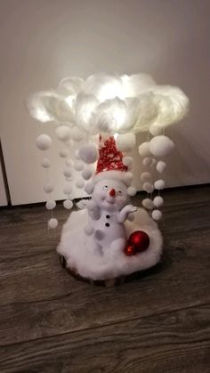 a snowman with a red hat on top of it's head in front of a white cloud