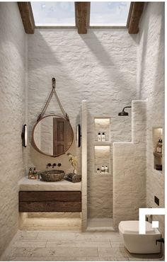 a bathroom with a sink, mirror and toilet in it's center wall next to a skylight