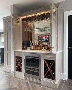 a home bar with wine glasses and bottles on the top shelf in front of it