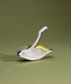 a silver spoon with a lemon slice in the shape of a fish on it's side