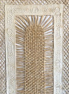 an art piece made out of wicker and rope with a white frame on the wall