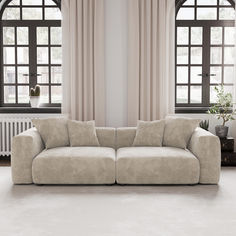 a couch sitting in front of two large windows