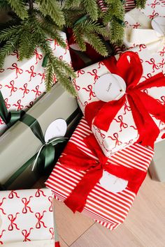 presents wrapped in red and white paper under a christmas tree