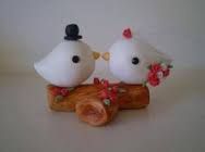 two white birds sitting on top of a piece of wood