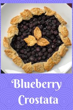 a blueberry crostaa pie on a plate with the words blueberry crostaa written below it