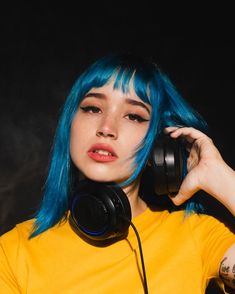 a woman with blue hair wearing headphones