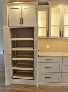 an empty pantry with white cabinets and drawers