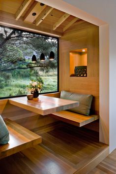 a wooden bench sitting next to a window in a room with wood floors and walls