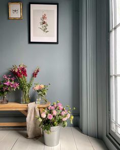 some flowers are sitting on a table in a room with blue walls and white floors