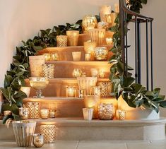 candles are lit on the steps in front of some plants