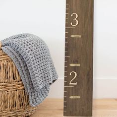 a crocheted hat sits next to a wooden ruler that reads,'3 22 '