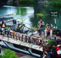 two men are playing music on a boat with bookshelves in the foreground