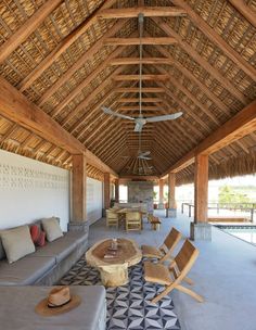 an outdoor living area with couches, tables and ceiling fan in the middle of it