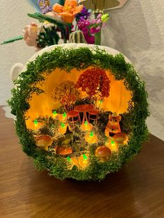 a bowl that is sitting on top of a table with flowers in the vase behind it