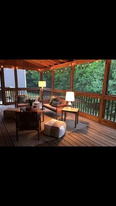 a living room filled with furniture on top of a hard wood flooring covered porch