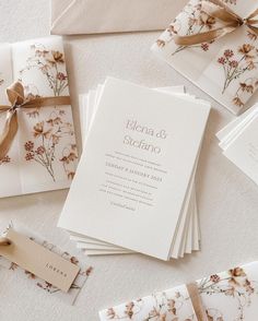 the wedding stationery is laid out on top of each other and tied with ribbon