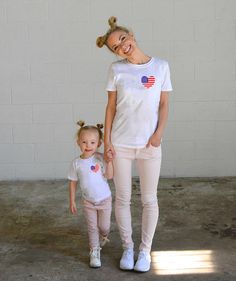 a mother and daughter standing together in front of a white wall with the words, blessed to her mom on it