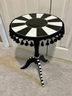 a black and white table with tassels on it sitting in front of a door