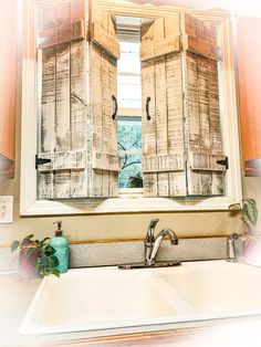 a bathroom sink sitting under a mirror next to a window with shutters on it