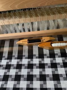 a close up of a weaving machine with yarn on the floor and in front of it