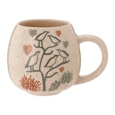 a ceramic mug with two birds perched on a tree