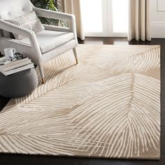 a white chair sitting on top of a wooden floor next to a rug covered in leaves