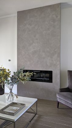 a living room filled with furniture and a fire place next to a wall mounted fireplace