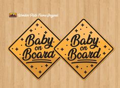 two baby on board stickers sitting on top of a wooden floor next to each other