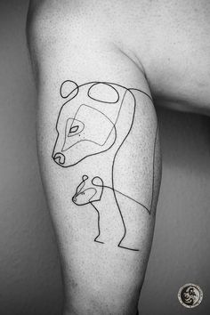 a man's leg with a line drawing of a bear and a bird on it