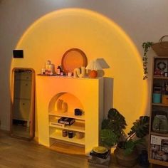 a living room with a yellow wall and white shelves filled with items on top of it