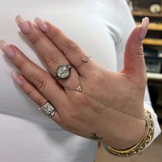 a woman's hand with several rings on it and a ring in the middle