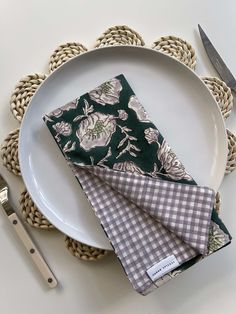 a white plate topped with two napkins next to a knife and fork on top of a table