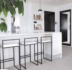 a kitchen with white counter tops and black barstools