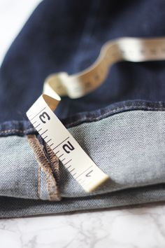 a measuring tape sticking out of the back pocket of a pair of jeans