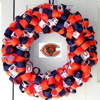 an orange and blue wreath with the chicago bears on it hanging from a white door