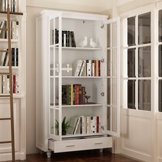 a white bookcase with many books in it