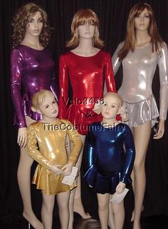 several mannequins in shiny clothing are posed for a photo with each other