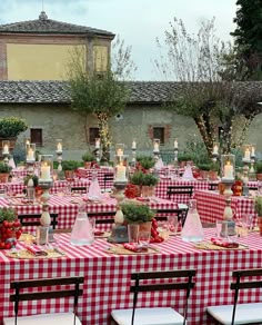 an outdoor dining area with red and white checkered tablecloths set up for dinner