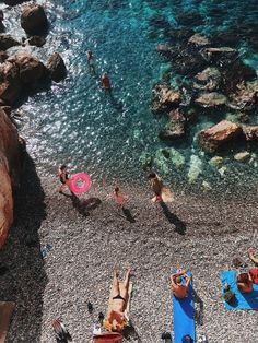 several people are on the beach and one is holding a pink frisbee in his hand