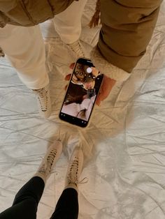 two people standing next to each other with their cell phones in the middle of them