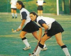 two girls are playing soccer on the field