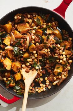 a skillet filled with beans, spinach and other vegetables