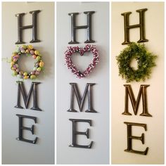 three metal letters that spell out the word home and heart wreaths on each letter