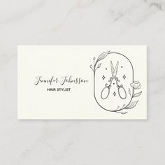 a business card with an illustration of scissors and flowers on the front, in black ink