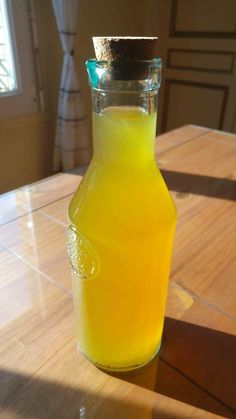 a glass bottle filled with liquid sitting on top of a wooden table