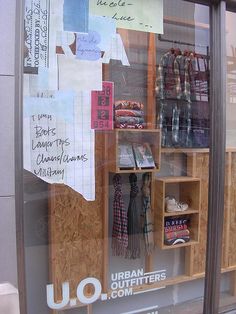 a store front window with clothes and other items in the display case on it's side