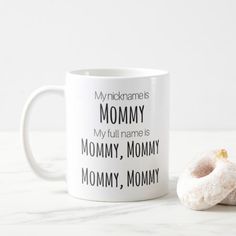 a white coffee mug with a donut on it and the words mommy written in black