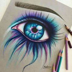 a drawing of an eye with colored pencils next to it